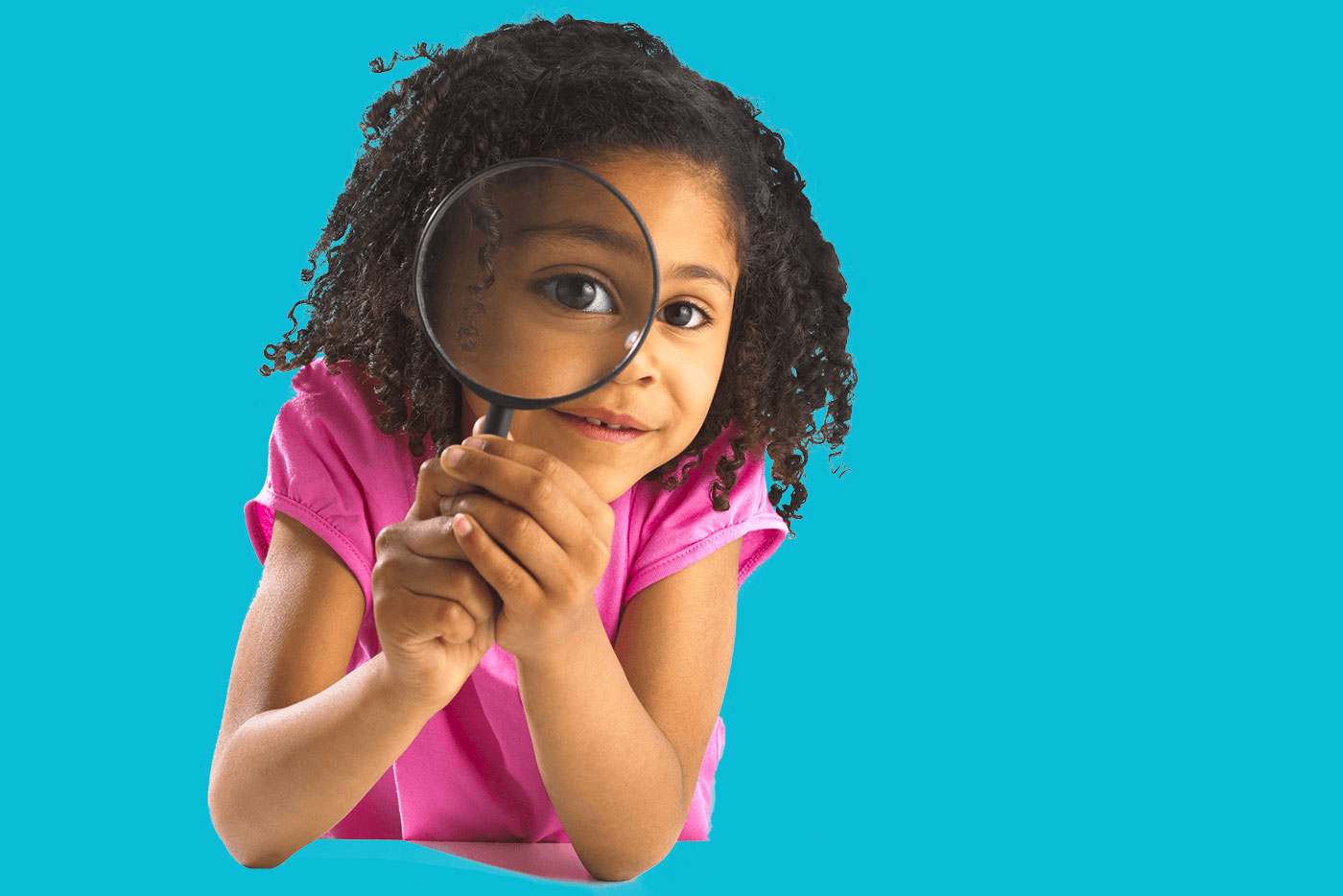 little girl looking through a magnifying glass